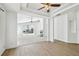Open-concept living room with modern flooring, ceiling fan, and a seamless connection to outdoor spaces at 1210 Paradise Lake Dr, Tarpon Springs, FL 34689