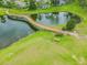 Scenic view of a curved wooden bridge over a pond enhancing the lush landscape at 1210 Paradise Lake Dr, Tarpon Springs, FL 34689