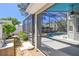View of the screen enclosed pool, featuring tropical landscaping from the side yard at 1210 Paradise Lake Dr, Tarpon Springs, FL 34689