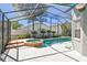 Screened in pool with an attached hot tub, patio, and tropical landscaping at 1210 Paradise Lake Dr, Tarpon Springs, FL 34689