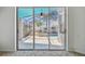 View from inside the house of the screened pool area, with a hot tub and patio furniture at 1210 Paradise Lake Dr, Tarpon Springs, FL 34689