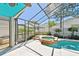 A covered pool with hot tub and screen, with a tropical backyard and a blue ceiling at 1210 Paradise Lake Dr, Tarpon Springs, FL 34689