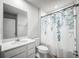 Cozy bathroom featuring a shower with a floral curtain, a white vanity, and a toilet at 12309 Grizzly Ln, New Port Richey, FL 34654