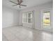 Bright bedroom with tile flooring, ceiling fan, and a door to the outside at 12309 Grizzly Ln, New Port Richey, FL 34654