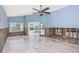 Bright living room with travertine floors, high ceilings, fan, and sliding doors to a pool at 1233 Eden Isle Ne Dr, St Petersburg, FL 33704