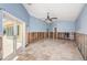 Spacious living room with tile flooring, ceiling fan, and glass doors leading to an outdoor space at 1233 Eden Isle Ne Dr, St Petersburg, FL 33704