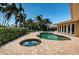 Backyard pool and patio featuring a kidney bean shaped pool and jacuzzi with pavers at 1233 Eden Isle Ne Dr, St Petersburg, FL 33704