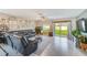 Inviting living room with a large sectional, entertainment center, and sliding glass doors to the backyard at 12960 Conquistador Loop, Spring Hill, FL 34610