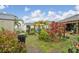 Well-manicured backyard features lush plants, shed, a cozy swing, and a view of the home's covered patio at 14407 Alistar Manor Dr, Wimauma, FL 33598