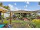 Lush backyard with a covered patio, greenery, various plants, and garden furniture, perfect for outdoor enjoyment at 14407 Alistar Manor Dr, Wimauma, FL 33598