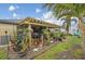 Relaxing backyard featuring a covered patio, lush greenery, various potted plants, and a private garden area at 14407 Alistar Manor Dr, Wimauma, FL 33598