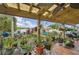 Cozy covered patio with hanging plants, a ceiling fan, comfortable seating, overlooking a landscaped backyard with a swing at 14407 Alistar Manor Dr, Wimauma, FL 33598