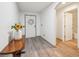 Bright entryway showcasing wood-look floors, decorative table with vase of flowers, and a wreath at 14407 Alistar Manor Dr, Wimauma, FL 33598