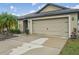 Exterior of house featuring a two-car garage, landscaping, and a well-maintained driveway at 14407 Alistar Manor Dr, Wimauma, FL 33598