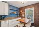 Charming eat-in kitchen with brick accent wall, natural light, and white cabinets at 14407 Alistar Manor Dr, Wimauma, FL 33598