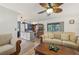 Bright living room showcasing wood floors, stylish ceiling fan, and an open-concept design to the kitchen at 14407 Alistar Manor Dr, Wimauma, FL 33598
