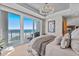 Primary bedroom featuring a beachfront view, large glass doors to balcony, and elegant lighting fixture at 15 Avalon St # 601, Clearwater Beach, FL 33767