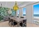 Dining room with a herringbone patterned table, statement wallpaper, modern chandelier, and ocean views at 15 Avalon St # 601, Clearwater Beach, FL 33767