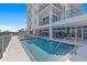 Condo's outdoor pool with clear blue water, deck chairs and steps for easy access at 15 Avalon St # 601, Clearwater Beach, FL 33767