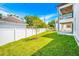 Lush green backyard with healthy grass, a tree, and a white vinyl fence at 1741 Nevada Ne Ave, St Petersburg, FL 33703