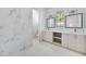Bright bathroom featuring marble tiling, double vanity with storage, and well-lit mirrors at 1741 Nevada Ne Ave, St Petersburg, FL 33703