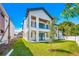 Stunning modern home with a white exterior, balcony, a well manicured lawn and beautiful landscaping at 1741 Nevada Ne Ave, St Petersburg, FL 33703