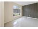 Modern, minimalist bedroom showcasing a decorative wall, large window, and neutral tile flooring at 18413 Eastwyck Dr, Tampa, FL 33647