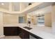 Bright kitchen featuring granite countertops, dark cabinets, and an open design leading to the living area and outdoor pool at 18413 Eastwyck Dr, Tampa, FL 33647