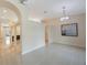 An open-concept living area showcasing tile flooring, decorative arches, and a modern chandelier at 18413 Eastwyck Dr, Tampa, FL 33647