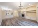 Spacious living room featuring a fireplace, built-in shelving, and wood floors, with an open layout to the kitchen at 18413 Eastwyck Dr, Tampa, FL 33647