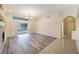 Bright living room featuring sliding glass doors to the pool area, wood floors, and a stylish chandelier at 18413 Eastwyck Dr, Tampa, FL 33647