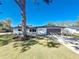 Charming single-story home featuring a manicured lawn, mature tree, and neutral color palette at 1991 67Th S Ave, St Petersburg, FL 33712