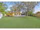 Large backyard with a lush lawn and a charming white picket fence enclosing the rear of the property at 2124 Crowsnest Dr, Palm Harbor, FL 34685