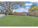 Expansive backyard featuring a large lawn and a wooden fence, providing privacy and ample space at 2124 Crowsnest Dr, Palm Harbor, FL 34685