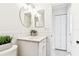 Bathroom featuring white tiles, a round mirror, and a marble countertop for a clean aesthetic at 2124 Crowsnest Dr, Palm Harbor, FL 34685