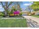 Charming yellow home featuring well-maintained landscaping, a two-car garage, and a welcoming front lawn at 2124 Crowsnest Dr, Palm Harbor, FL 34685
