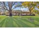 Expansive front yard featuring a well-manicured lawn and mature trees that add to the property's curb appeal at 2124 Crowsnest Dr, Palm Harbor, FL 34685