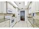 Well-lit kitchen with granite countertops, tile backsplash, and white cabinetry at 2124 Crowsnest Dr, Palm Harbor, FL 34685