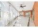 Bright sunroom featuring tile floors, ceiling fans, and sheer curtains allowing natural light to fill the space at 2124 Crowsnest Dr, Palm Harbor, FL 34685