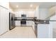 Modern kitchen with stainless steel appliances, granite counters, white cabinets, and tile floors at 21385 Darter Rd, Land O Lakes, FL 34638