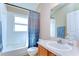 Bathroom featuring a tub, blue patterned shower curtain, white tiling, and a single vanity at 2542 Clareside Dr, Valrico, FL 33596
