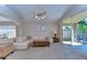 Bright living room with a white sectional couch, wooden coffee table, and sliding glass doors to the outdoor patio at 2542 Clareside Dr, Valrico, FL 33596