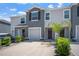 A modern two-story townhome shows a well-maintained lawn, an attached single car garage, and neutral color palette at 2892 Beluga Bay Dr, Odessa, FL 33556