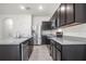Modern kitchen with stainless steel appliances, granite countertops, and dark wood cabinetry at 2892 Beluga Bay Dr, Odessa, FL 33556