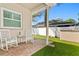 Relaxing back porch featuring brick pavers, two rocking chairs and a view of the manicured backyard at 3003 Magdalene Woods Dr, Tampa, FL 33618