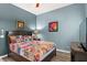 Inviting bedroom featuring a queen bed, wooden floors, and vibrant wall art at 3003 Magdalene Woods Dr, Tampa, FL 33618