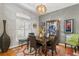Dining room with modern chandelier, display cabinet, and plantation shutters, for an intimate, stylish experience at 3003 Magdalene Woods Dr, Tampa, FL 33618