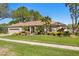 Charming front exterior with a well-manicured lawn and a long brick driveway at 3003 Magdalene Woods Dr, Tampa, FL 33618