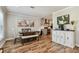 Well-lit dining area open to kitchen features wood-look flooring, modern art, and neutral tones at 3212 W Hartnett Ave, Tampa, FL 33611