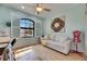 Bright bedroom featuring wood floors, plantation shutters, and a ceiling fan at 329 Laurel Falls Dr, Apollo Beach, FL 33572